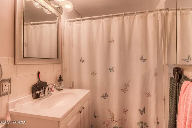 a bathroom with a sink a vanity and a shower curtain