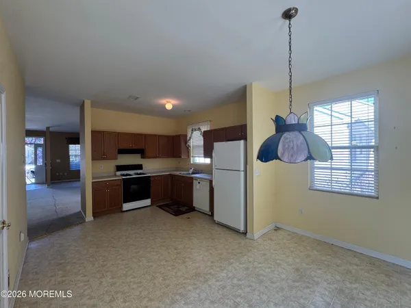 a kitchen with stainless steel appliances kitchen island granite countertop a refrigerator a oven a sink with a countertop and wooden floor
