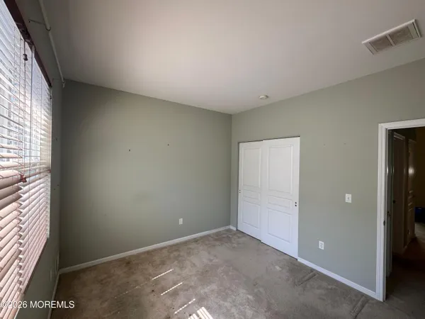an empty room with closet and ceiling fan