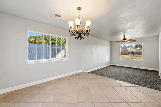 an empty room with windows and chandelier