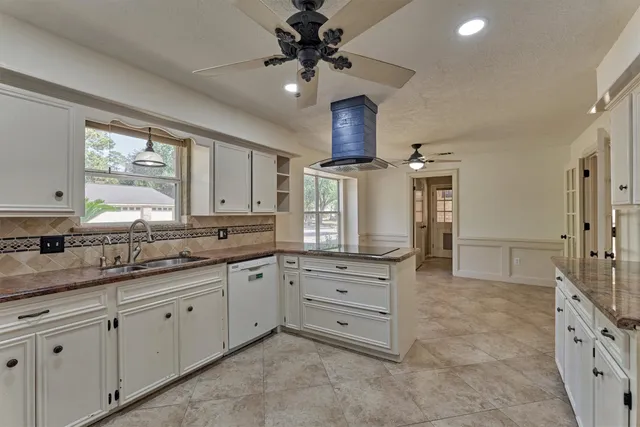 a kitchen with granite countertop a sink stainless steel appliances and cabinets