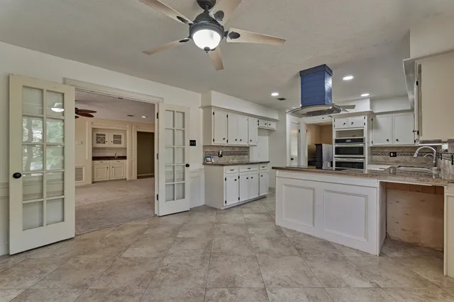 a large kitchen with cabinets and stainless steel appliances