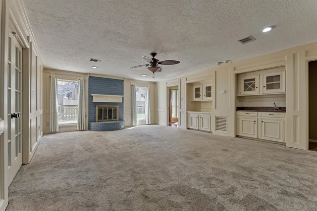 a view of an empty room with a fireplace and a window