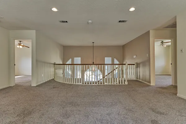 an empty room with a ceiling fan and window