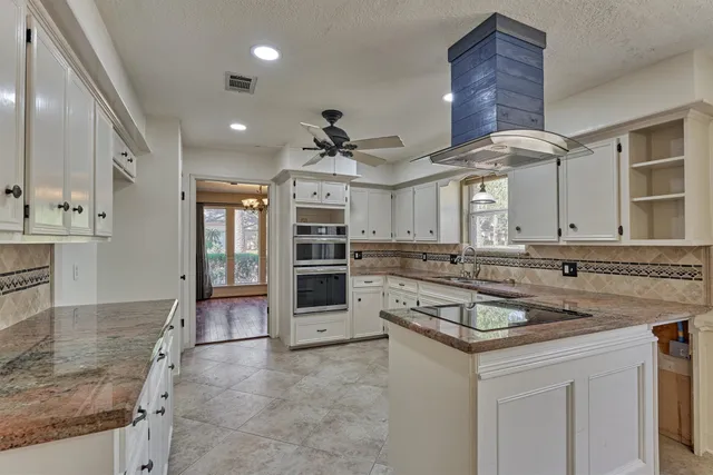a kitchen with stainless steel appliances granite countertop a sink a stove and cabinets