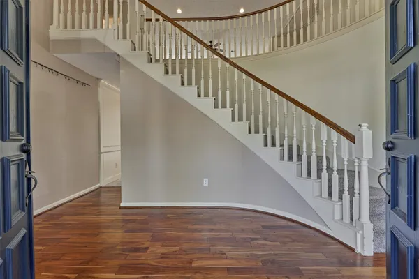 a view of staircase with wooden floor and white walls