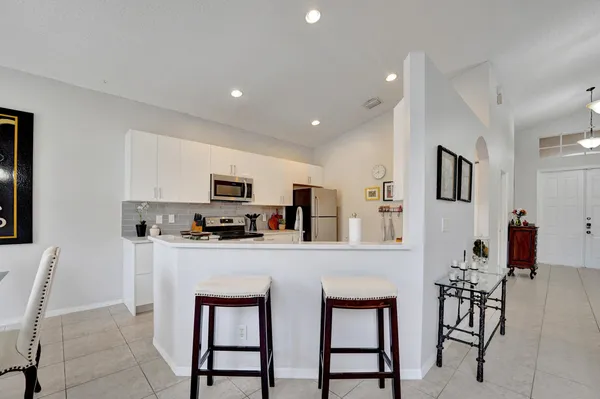 a kitchen with stainless steel appliances a microwave a stove a table and chairs