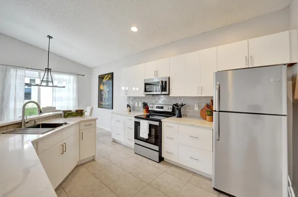 a kitchen with white cabinets and white appliances