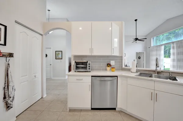 a kitchen with white cabinets and white appliances