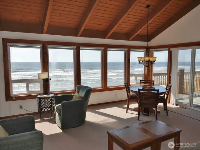 a living room with furniture and floor to ceiling windows