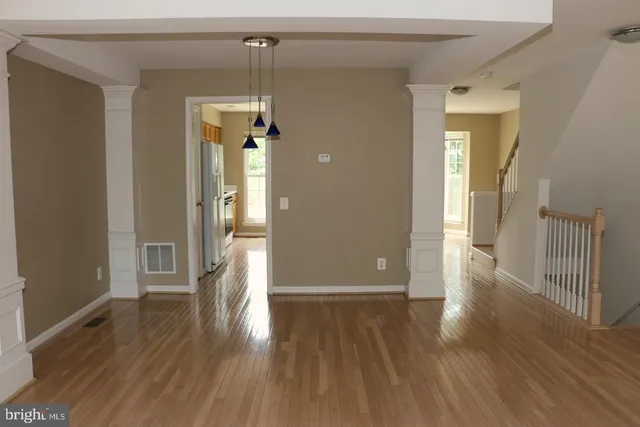 a view of a hallway with wooden floor and stairs