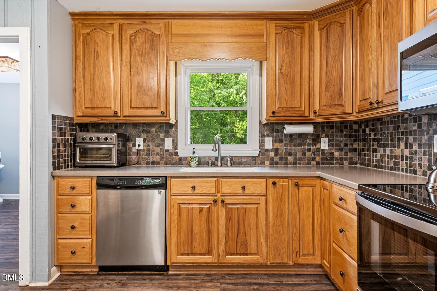 134 Longview Road Madison, NC 27025 - Photo 14 of 49 a kitchen with granite countertop wooden cabinets a sink and a window