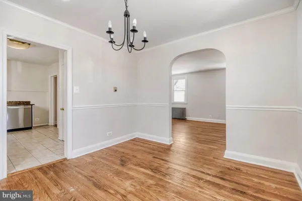 a view of a livingroom with wooden floor and kitchen space