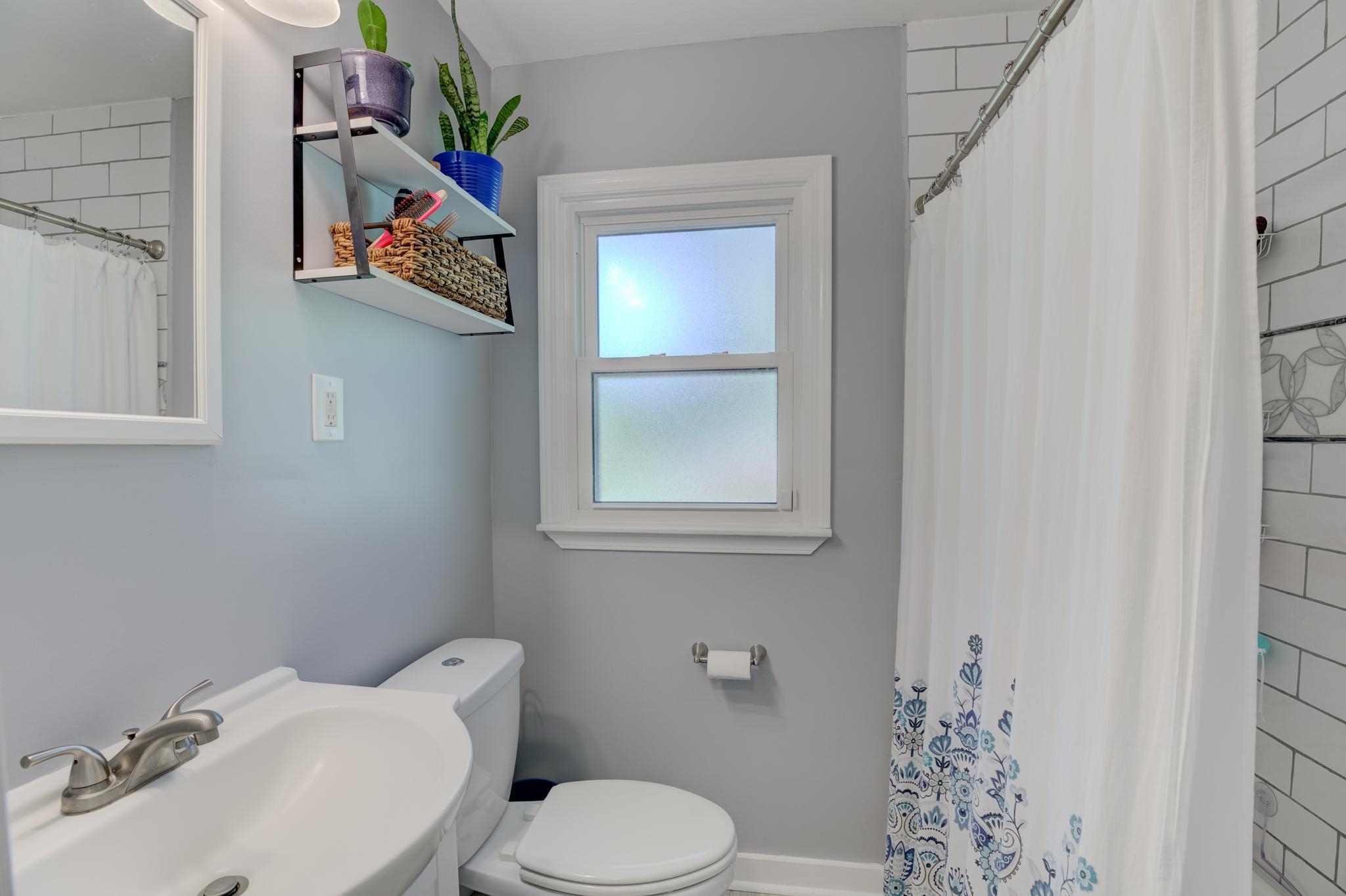 1421 Flamingo Road Memphis, TN 38117 - Photo 14 of 23 a white toilet sitting next to a bathroom sink