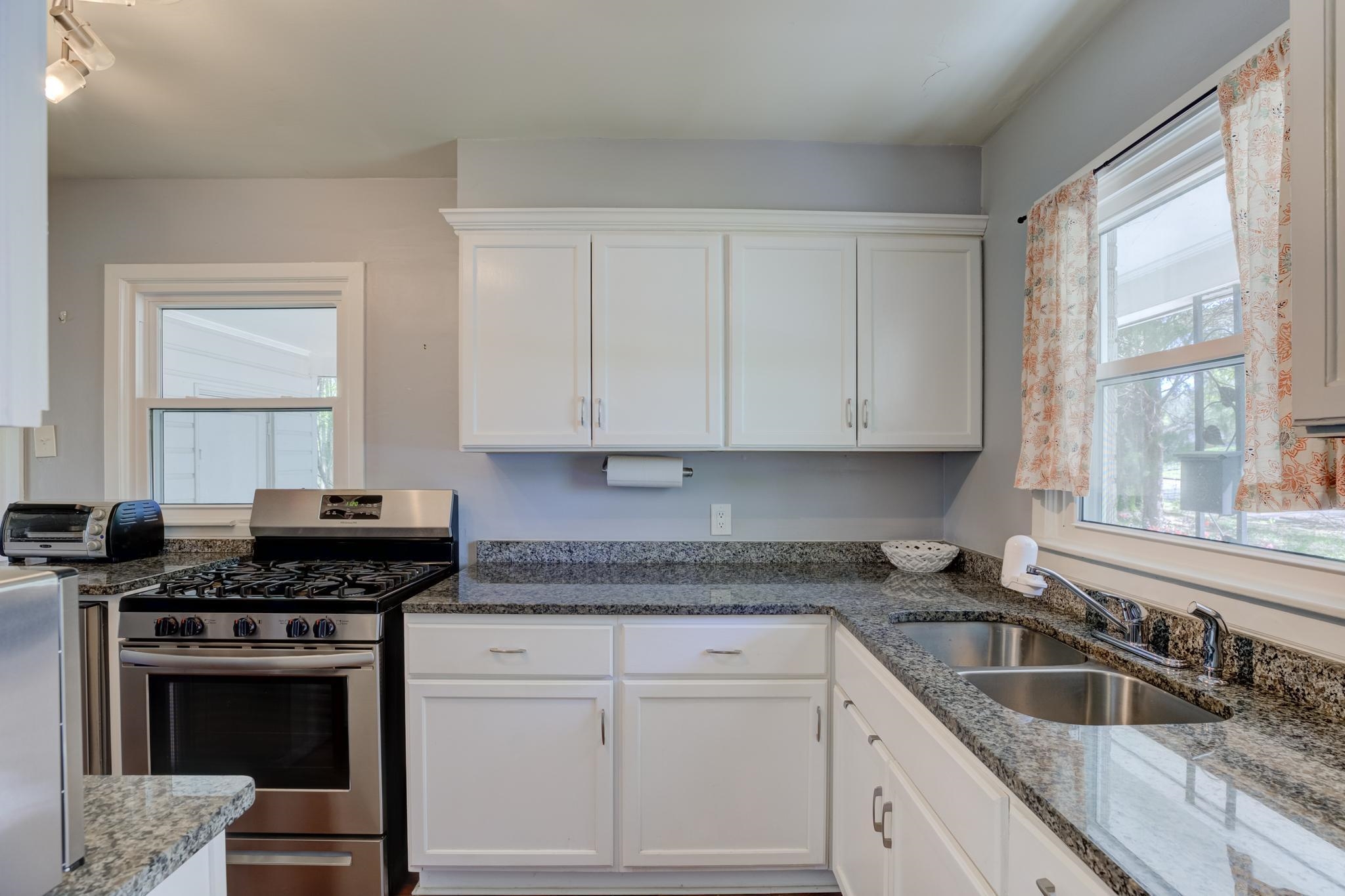 1421 Flamingo Road Memphis, TN 38117 - Photo 3 of 23 a kitchen with granite countertop a stove sink and cabinets