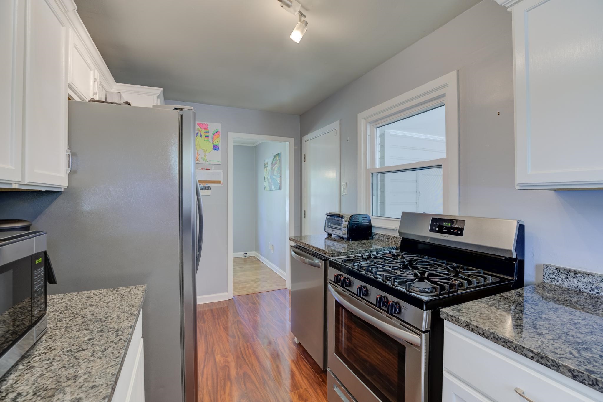 1421 Flamingo Road Memphis, TN 38117 - Photo 4 of 23 a kitchen with a stove and a wooden floor