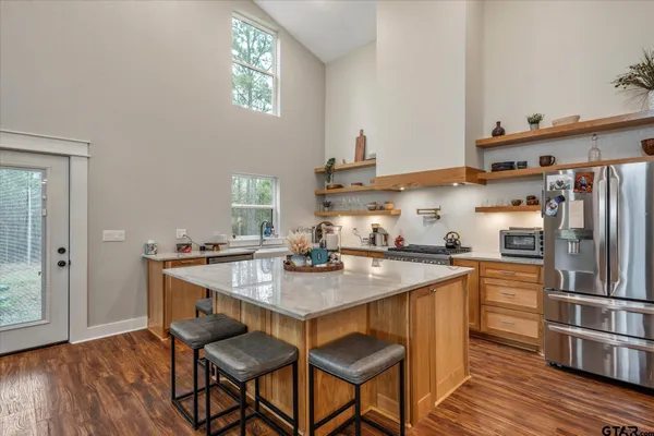 a view of a dining room and livingroom with furniture wooden floor a chandelier