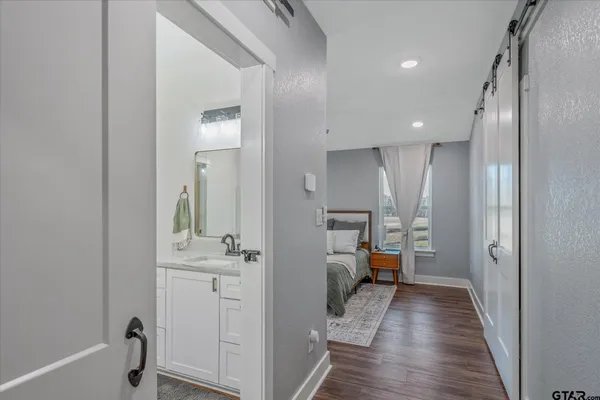 a bathroom with a granite countertop double vanity sink a mirror and a shower