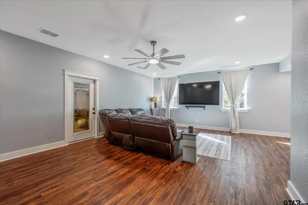a living room with furniture and a wooden floor
