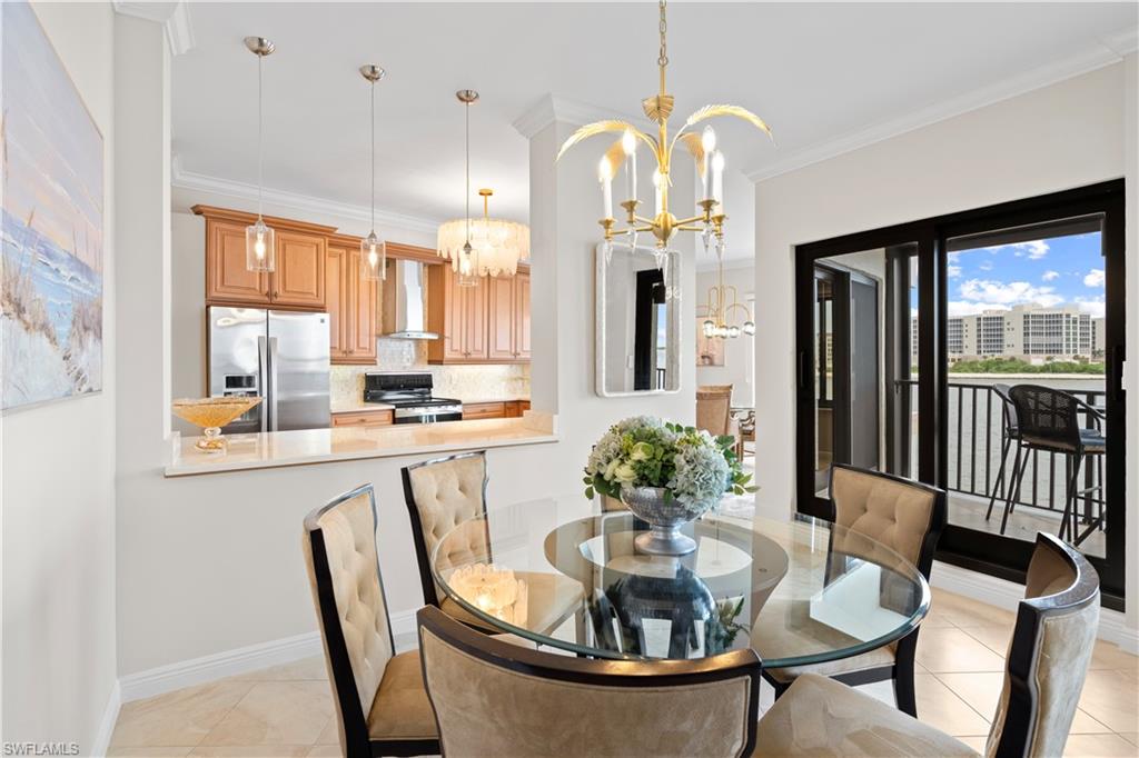 524 La Peninsula Boulevard, Unit 524 Naples, FL 34113 - Photo 16 of 44 a view of a dining room with furniture window and wooden floor