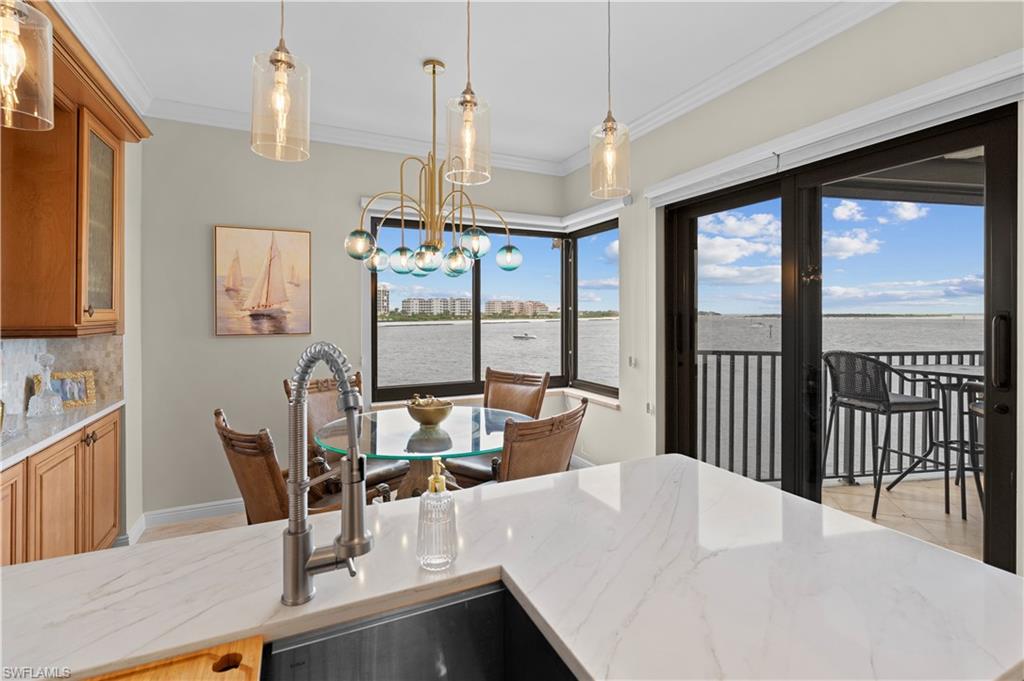 524 La Peninsula Boulevard, Unit 524 Naples, FL 34113 - Photo 22 of 44 a view of a dining room with furniture large windows and wooden floor