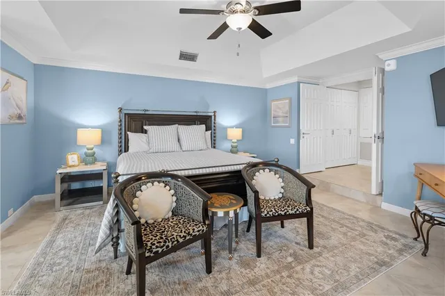 a spacious bedroom with a bed and a flat screen tv