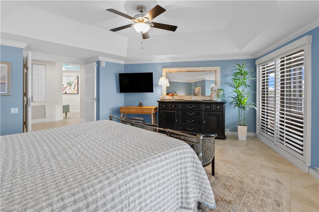 524 La Peninsula Boulevard, Unit 524 Naples, FL 34113 - Photo 31 of 44 a bedroom with a bed and a flat screen tv