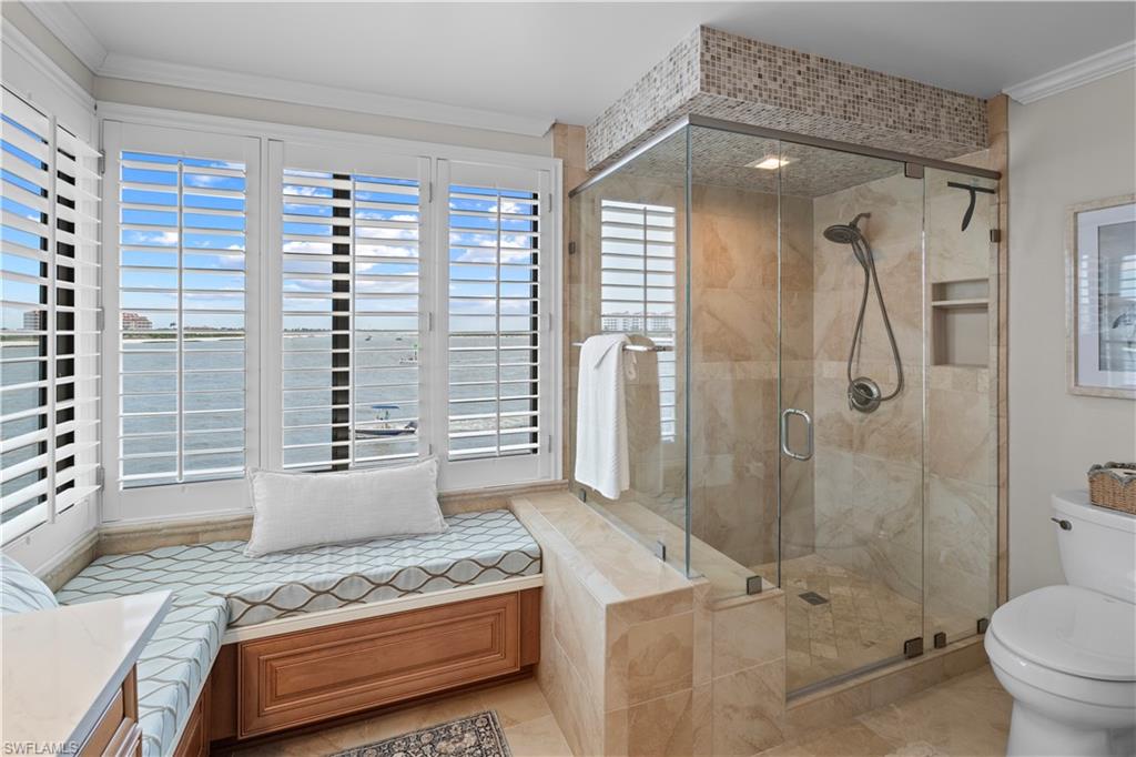 524 La Peninsula Boulevard, Unit 524 Naples, FL 34113 - Photo 33 of 44 a bathroom with a granite countertop sink a toilet and shower