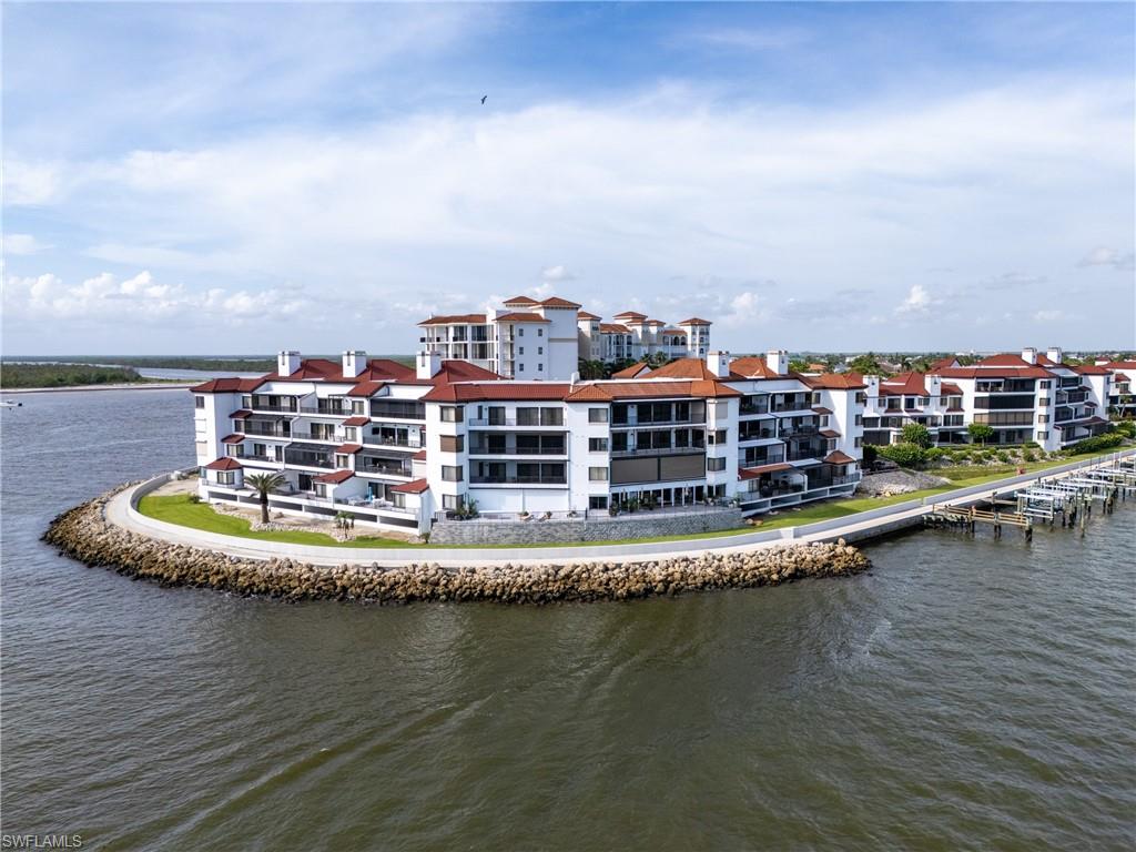 524 La Peninsula Boulevard, Unit 524 Naples, FL 34113 - Photo 44 of 44 a view of a lake with a multi story residential apartment building in front of it