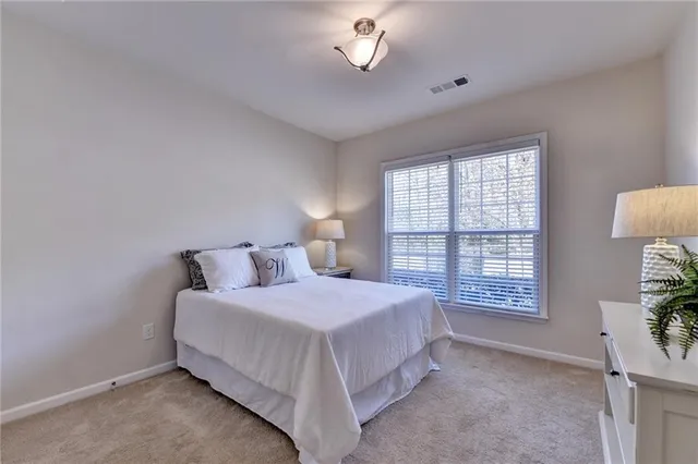 a bedroom with a bed a chandelier and a window