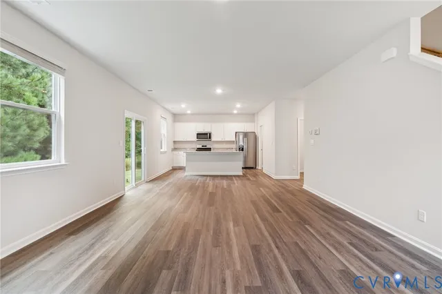 a view of a living room hardwood floor and a kitchen