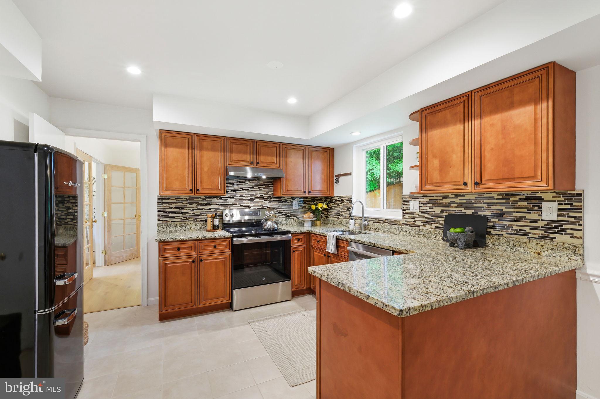10900 Gainsborough Road Potomac, MD 20854 - Photo 12 of 44 a kitchen with stainless steel appliances granite countertop sink stove and refrigerator