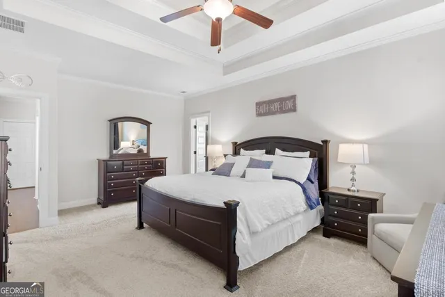 a spacious bedroom with a bed a couch and a chandelier