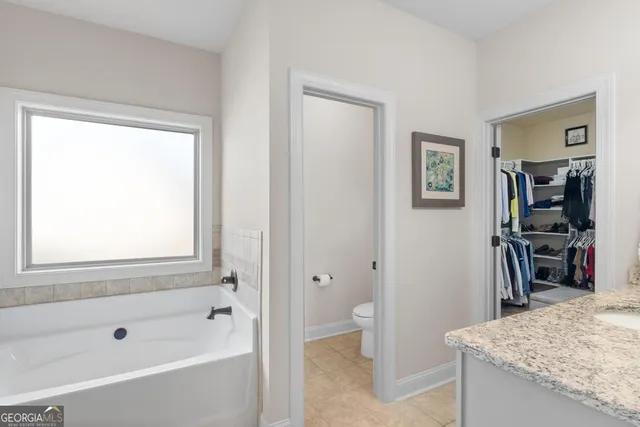 a bathroom with a granite countertop sink a toilet and shower