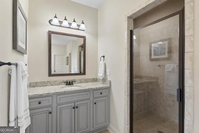 a bathroom with a granite countertop sink vanity and mirror