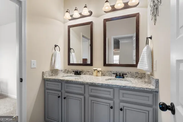 a bathroom with a granite countertop sink a mirror a vanity and a bathtub