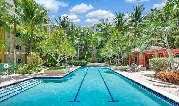 a view of backyard with swimming pool and seating space