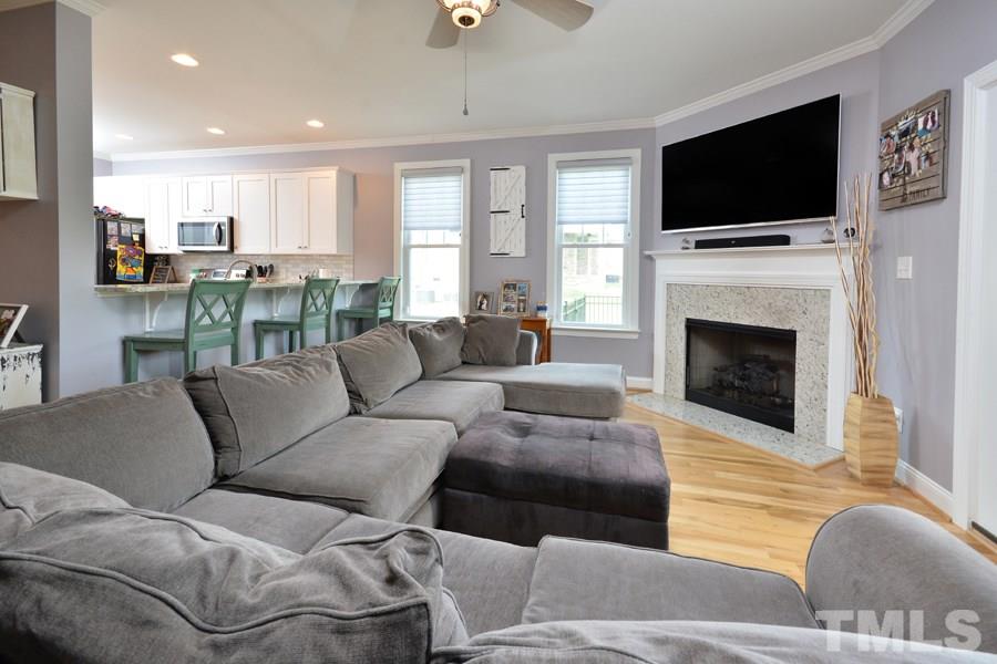 41 South Old Lantern Road Timberlake, NC 27583 - Photo 13 of 25 a living room with furniture a fireplace and a flat screen tv
