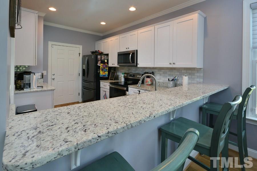 41 South Old Lantern Road Timberlake, NC 27583 - Photo 9 of 25 a kitchen with granite countertop a sink a stove refrigerator and microwave
