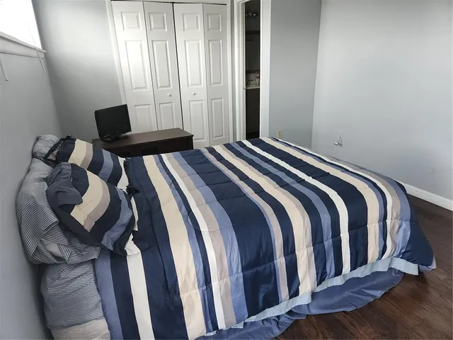 a bedroom with a bed and wooden floor