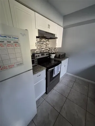 a kitchen with granite countertop a stove and a sink
