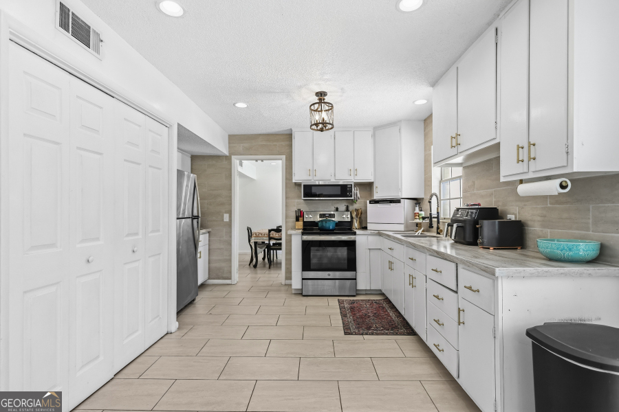 168 Pierce Street Jesup, GA 31545 - Photo 11 of 30 a kitchen with stainless steel appliances a refrigerator sink and cabinets