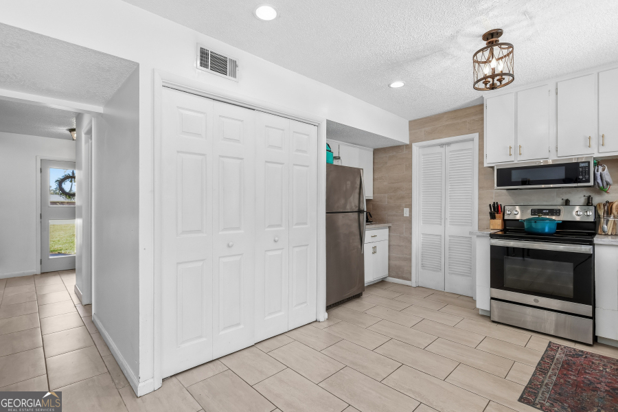 168 Pierce Street Jesup, GA 31545 - Photo 12 of 30 a kitchen with stainless steel appliances a refrigerator and a stove top oven