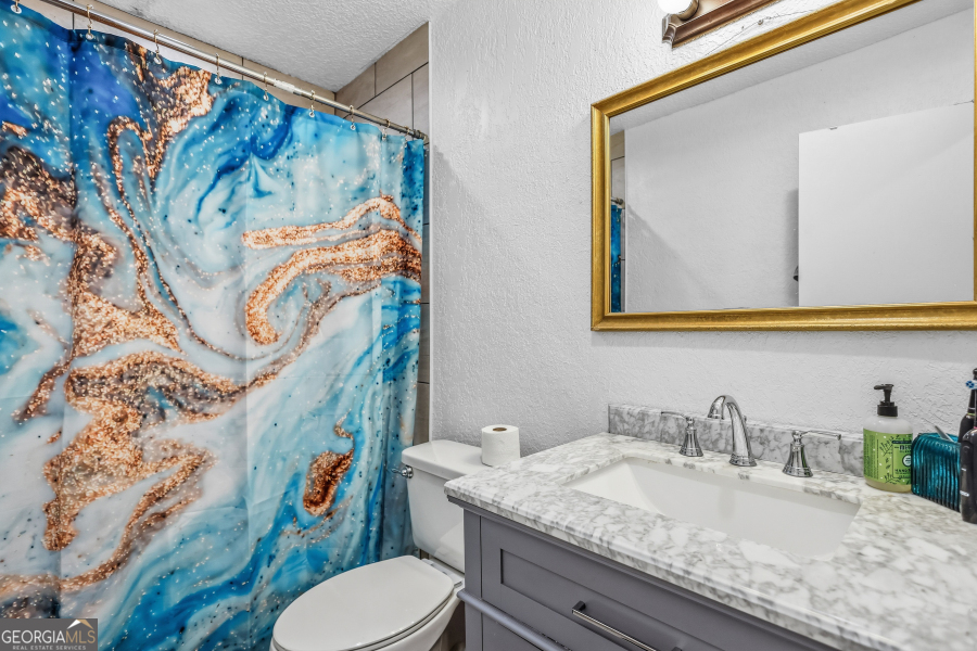 168 Pierce Street Jesup, GA 31545 - Photo 19 of 30 a bathroom with a granite countertop sink and a mirror