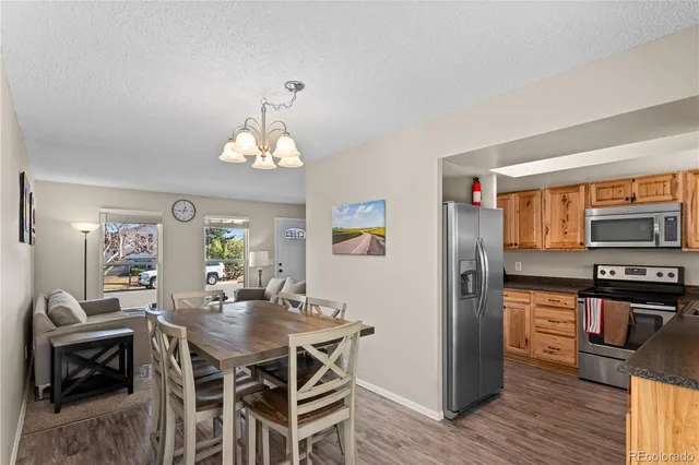 a kitchen with stainless steel appliances granite countertop a sink a stove and a refrigerator