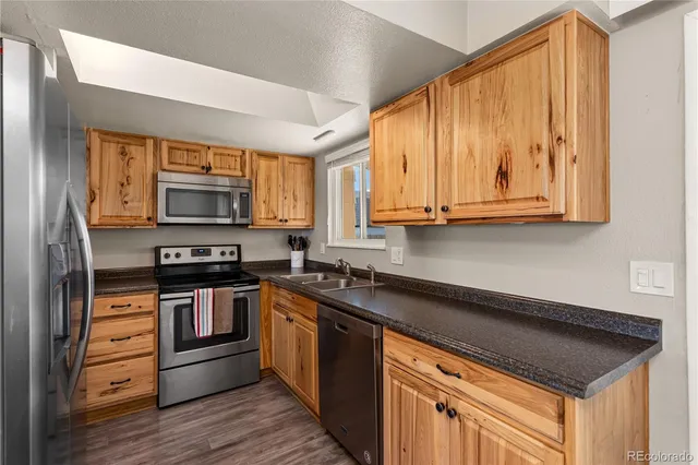 a kitchen with stainless steel appliances granite countertop white cabinets and a stove top oven