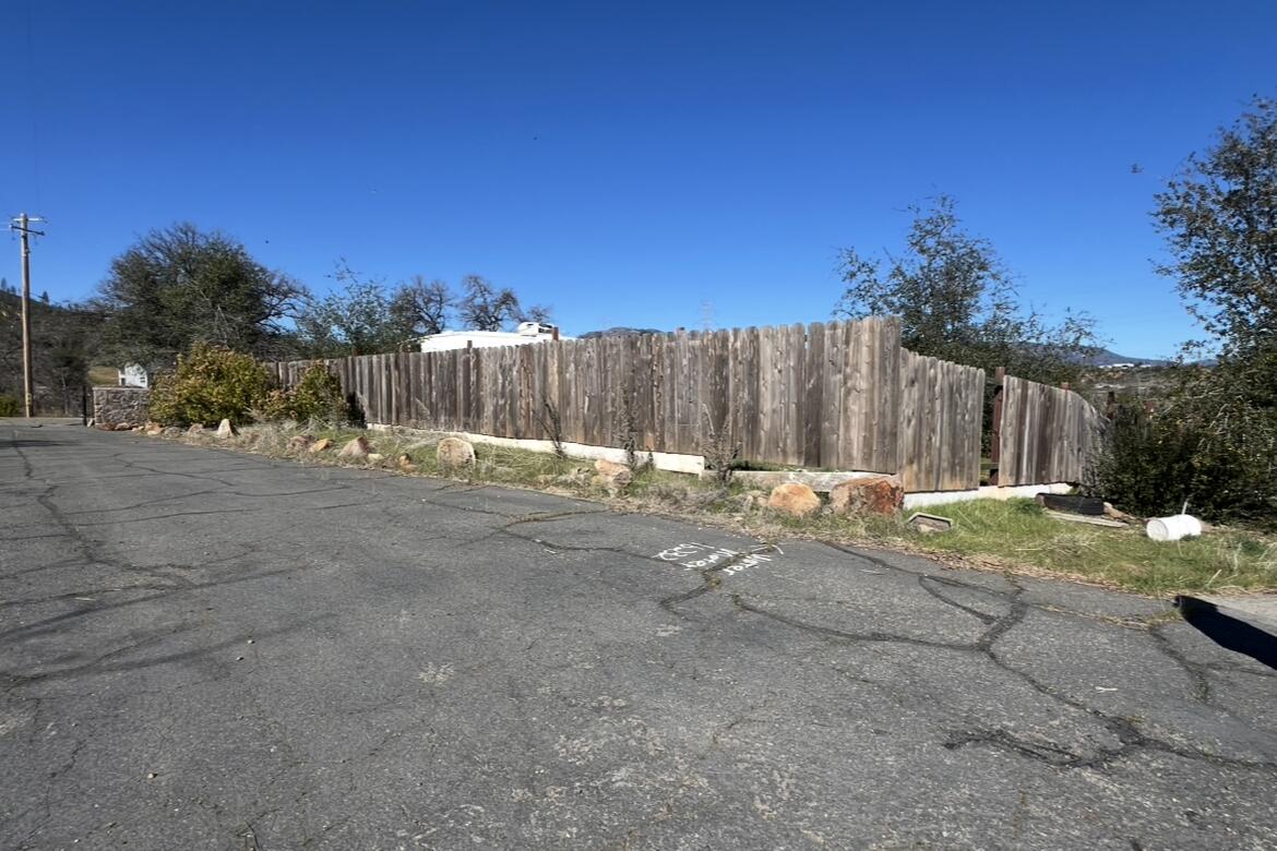 16266 Gold Pan Way Redding, CA 96001 - Photo 2 of 9 a view of backyard with wooden fence and trees