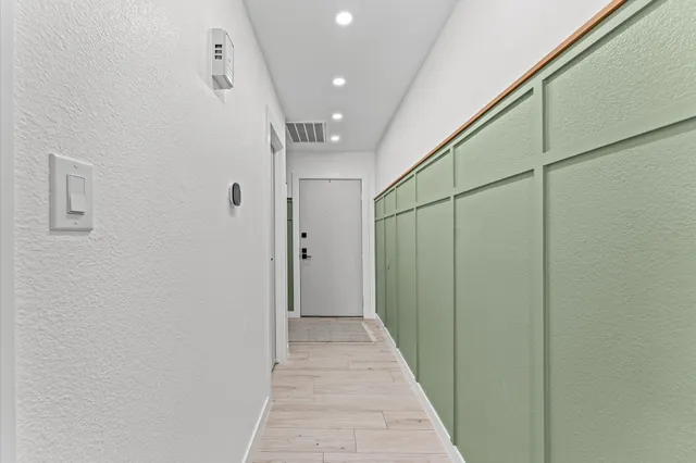 a view of a hallway with wooden floor and staircase