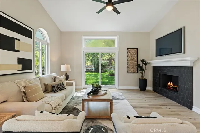 a living room with furniture a fireplace a flat screen tv and view