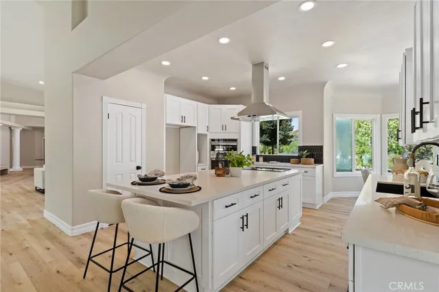 a kitchen with kitchen island granite countertop a sink cabinets and wooden floor